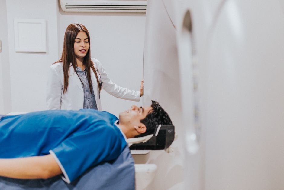 A doctor stands beside a patient in an MRI room, ensuring a smooth examination p