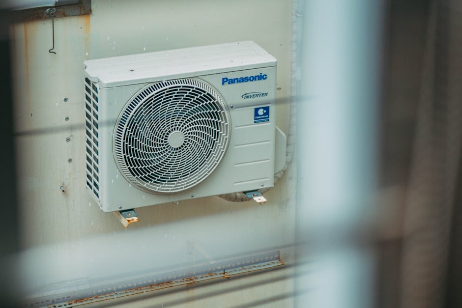 Air conditioner unit mounted outdoors on a building wall, showcasing modern HVAC