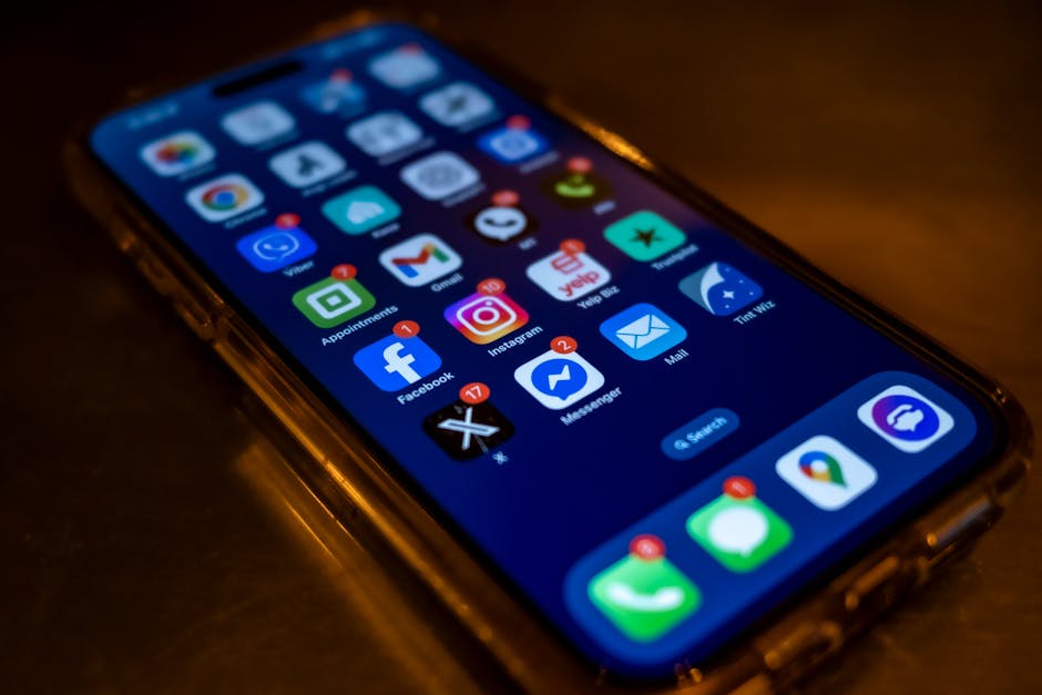 Smartphone screen displaying social media app notifications in a dimly lit setti