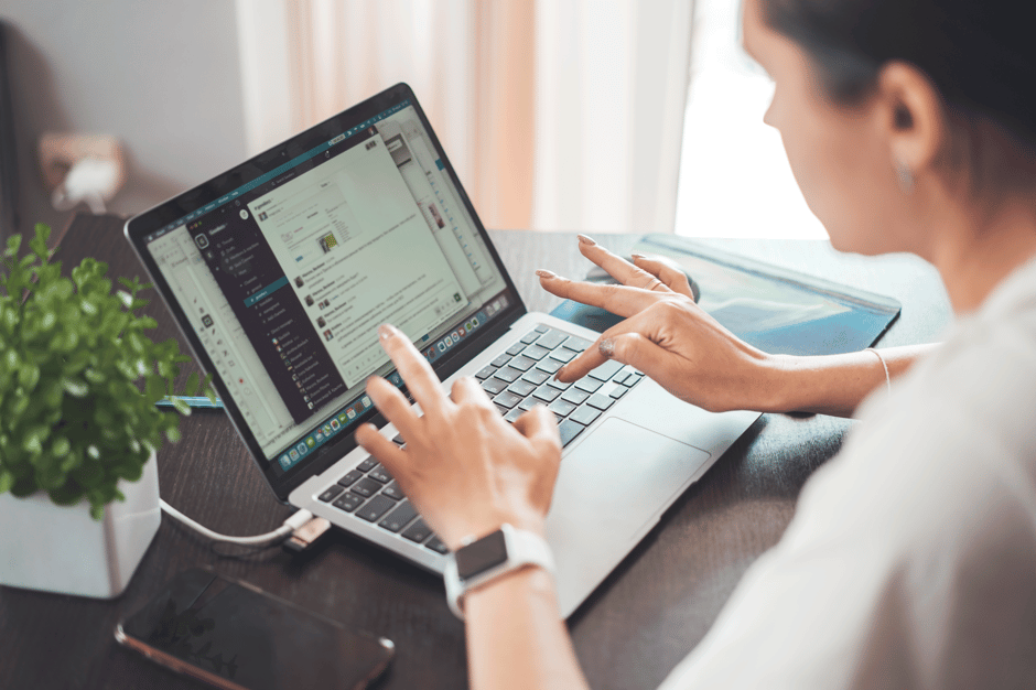 A woman working on a laptop from home, focusing on digital tasks and communicati