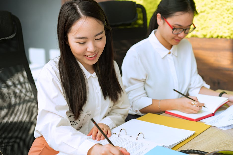Two young professionals working together in a bright office environment, taking 