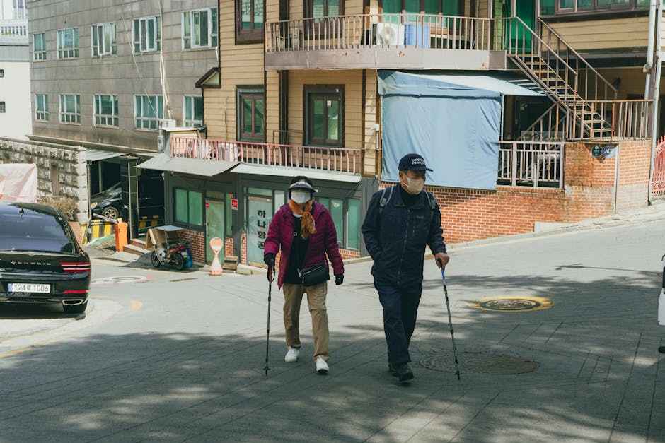 Elderly couple with walking sticks strolling a hilly street in Seoul, South Kore