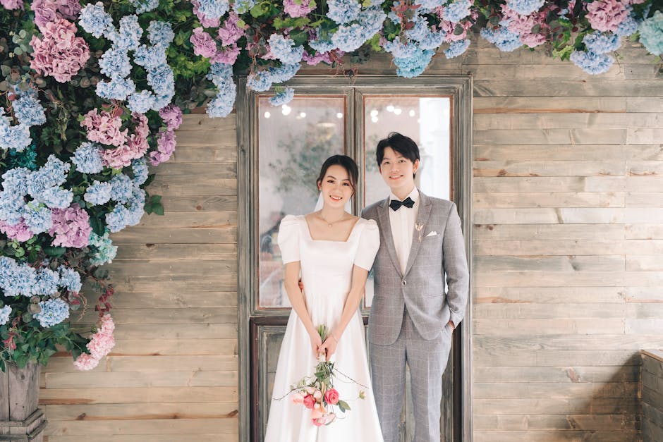 Beautiful bride and groom posing happily in front of floral backdrop, perfect fo