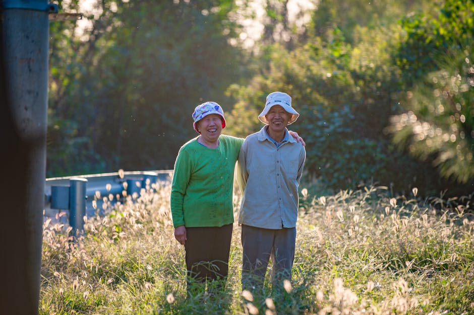 A happy senior couple enjoying a sunny day outdoors, embracing in a green field.