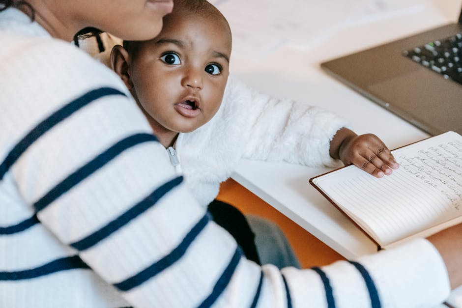 Indian child with woman in casual clothes at table with opened notepad and netbo