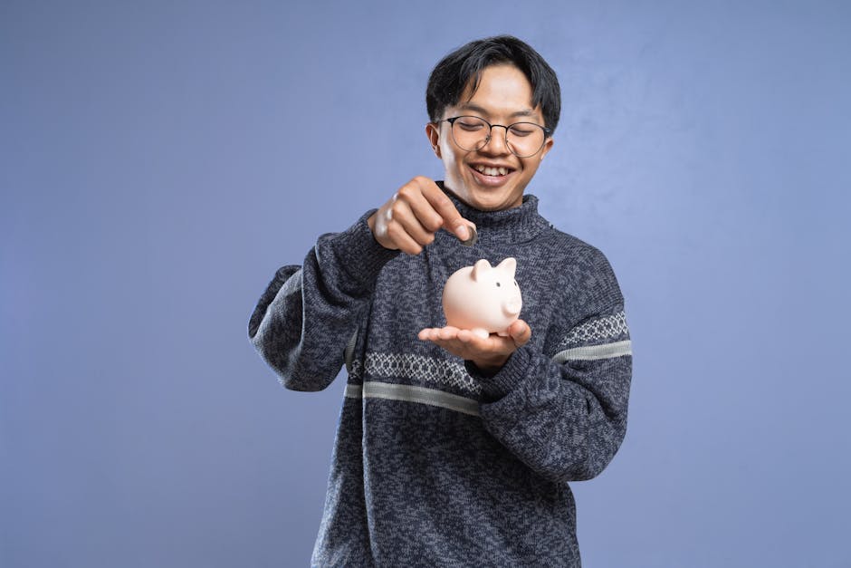 Smiling man holding a piggy bank and inserting a coin, representing savings and