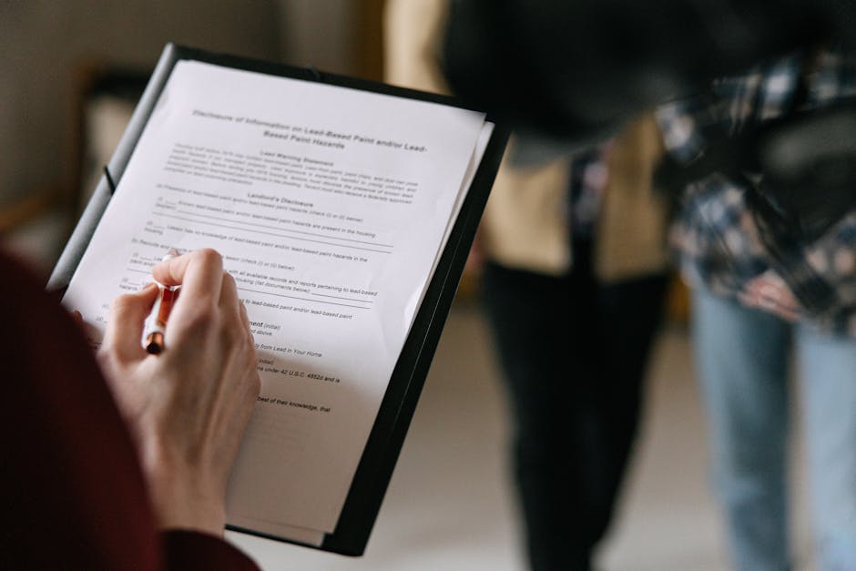 A couple examines real estate documents indoors with focus on writing and discus