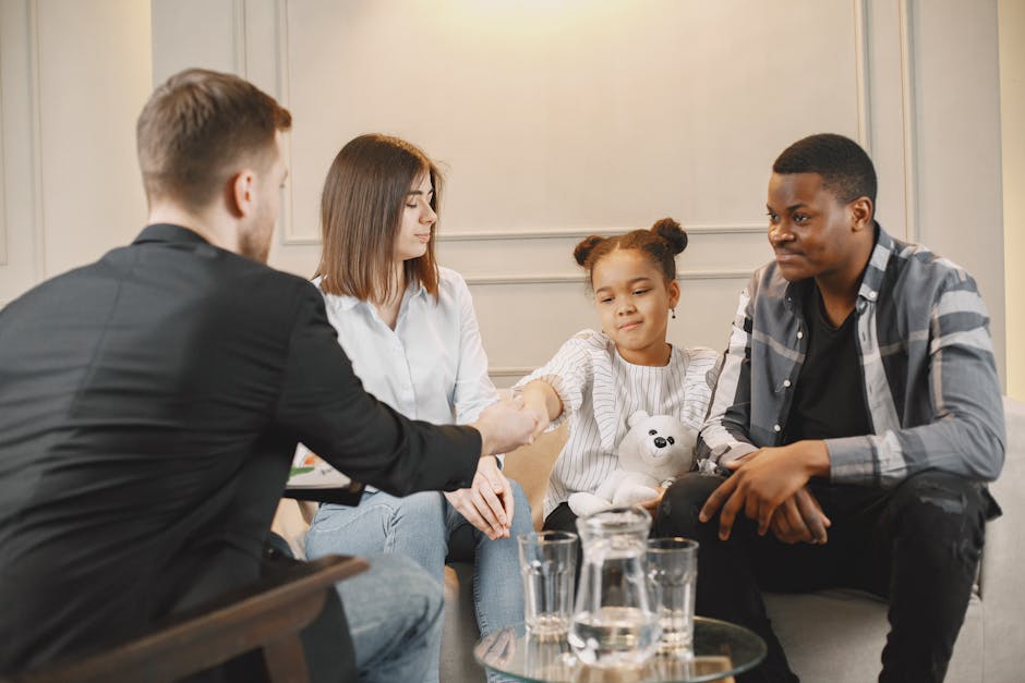 A family in a thoughtful counselling session with a professional in a modern set