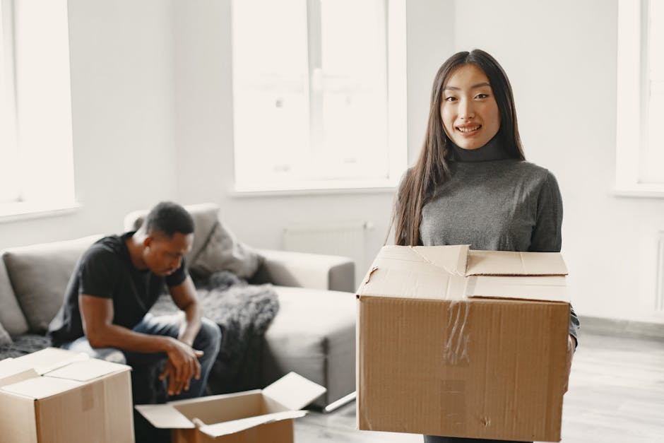 A couple happily unpacks moving boxes in their new apartment.