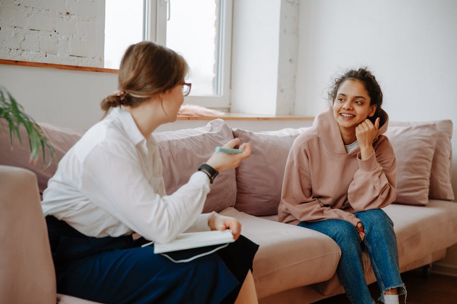 A therapist and young client engaging in a warm counseling session on a cozy sof